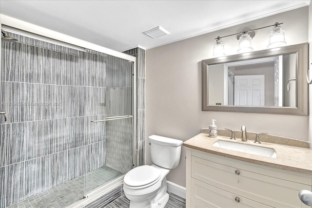 bathroom with vanity, a shower with door, and toilet