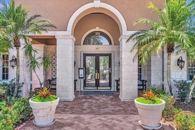 3659 NW Adriatic Ln Unit 305, Jensen Beach, FL 34957 - view of exterior entry featuring french doors and stone siding
