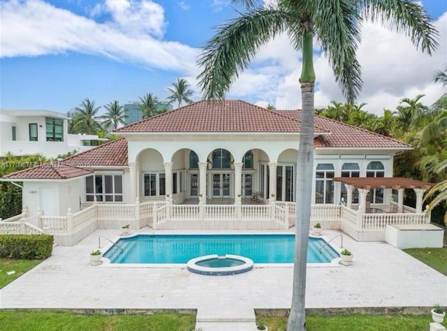 back of property featuring a pergola, a patio area, and a swimming pool with hot tub