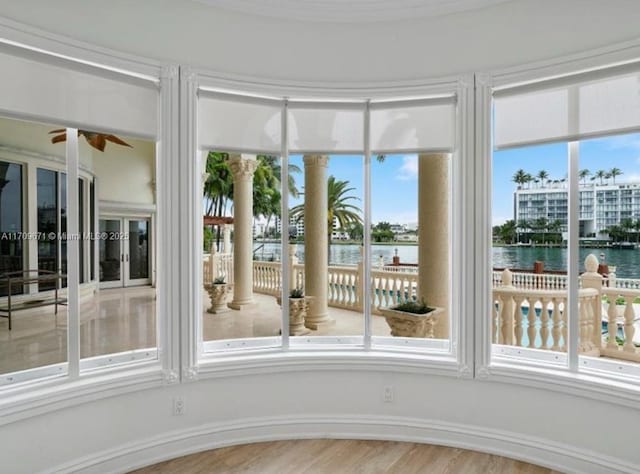 unfurnished sunroom featuring a water view and ceiling fan