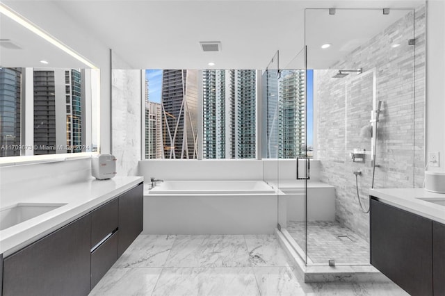 bathroom with plus walk in shower, vanity, and plenty of natural light