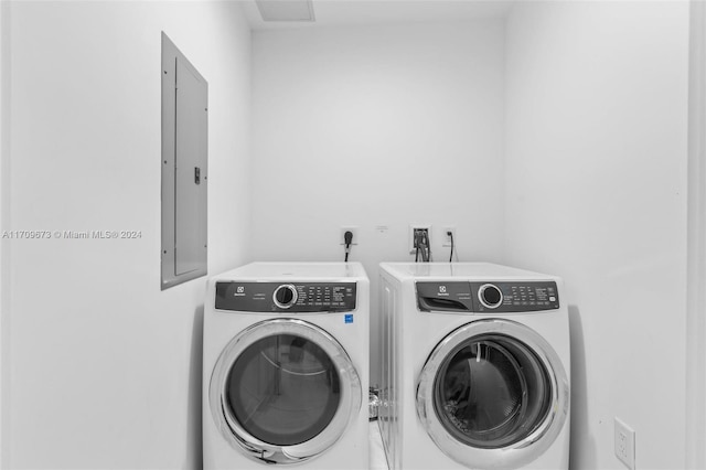 clothes washing area featuring electric panel and washer and clothes dryer