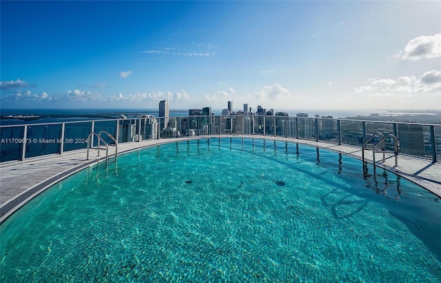 view of swimming pool with a water view and a patio area