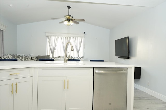 kitchen featuring vaulted ceiling, stainless steel dishwasher, sink, and white cabinets