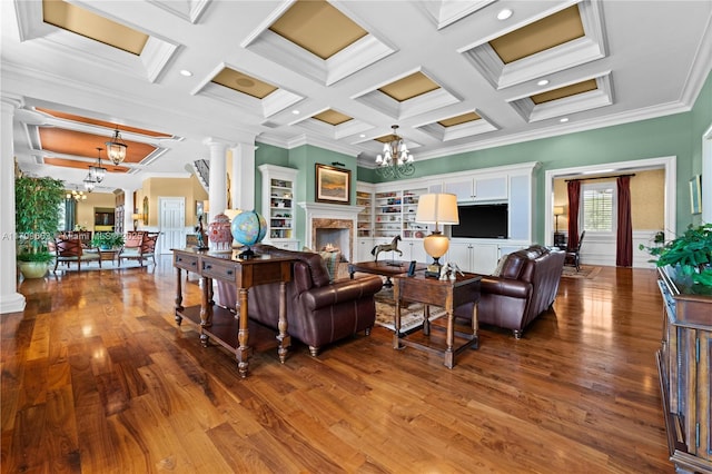 living room featuring ornamental molding, coffered ceiling, built in shelves, an inviting chandelier, and beamed ceiling