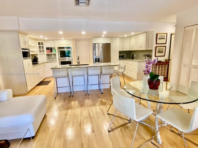 dining space featuring light wood-type flooring and sink