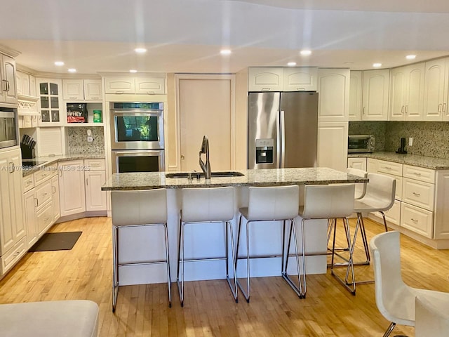 kitchen with light stone counters, white cabinets, and stainless steel appliances