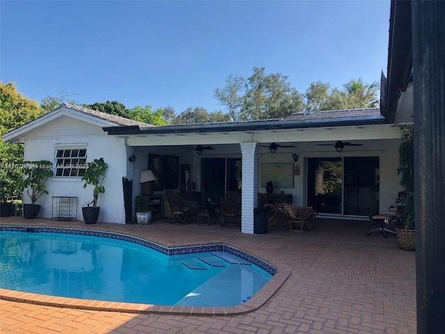 view of swimming pool with ceiling fan and a patio