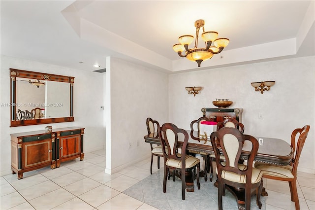 dining space with a raised ceiling, light tile patterned flooring, and a notable chandelier