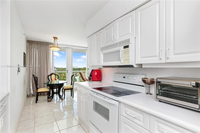 kitchen with pendant lighting, white cabinetry, light tile patterned flooring, and white appliances