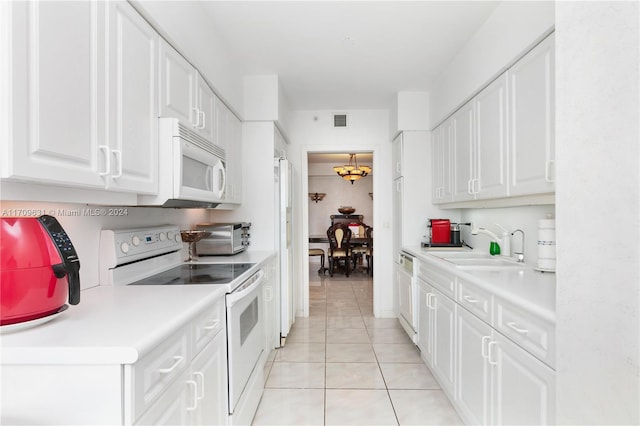 kitchen featuring white cabinetry, sink, light tile patterned floors, and white appliances