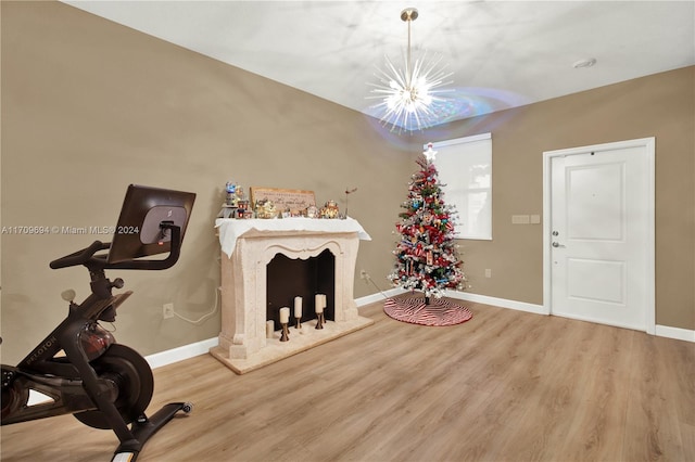 exercise area with hardwood / wood-style floors and a chandelier