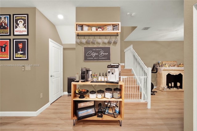 staircase with wood-type flooring and lofted ceiling