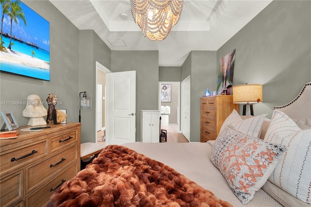 bedroom with a tray ceiling and a notable chandelier