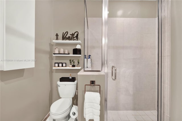 bathroom with toilet and a shower with shower door