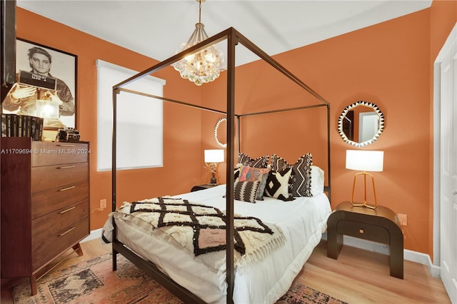 bedroom with hardwood / wood-style flooring and a chandelier