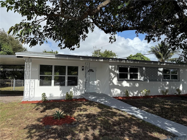 view of front facade featuring a front lawn and a carport