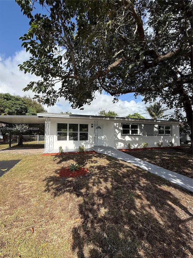 view of front facade featuring a front lawn and a carport