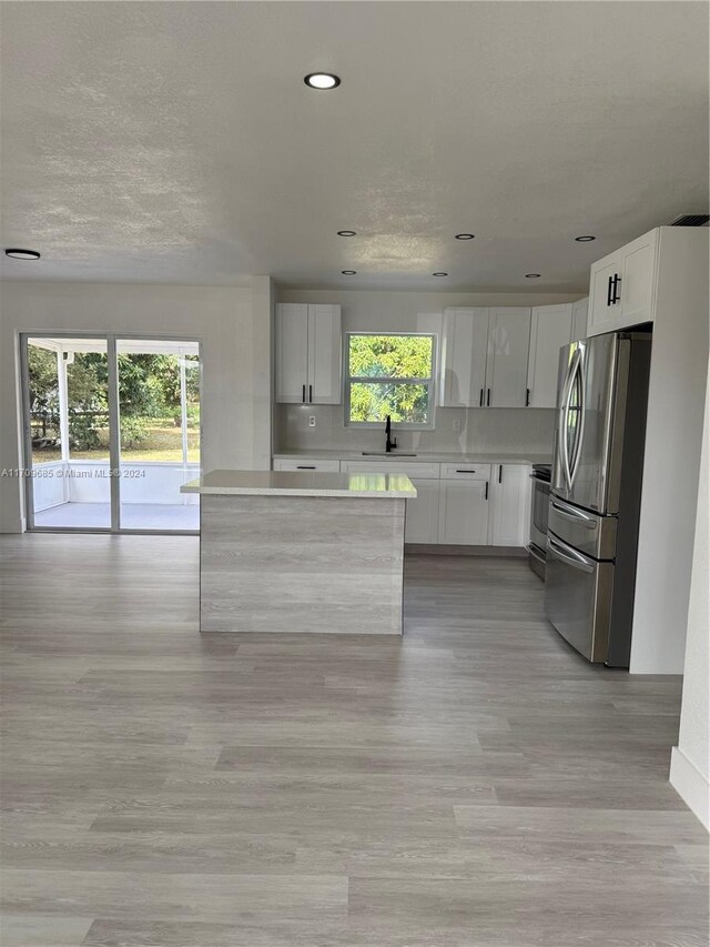 kitchen with plenty of natural light, white cabinetry, sink, and appliances with stainless steel finishes