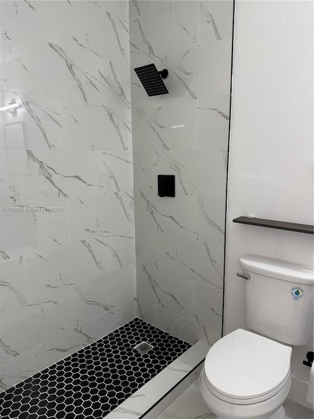 bathroom with tiled shower and toilet