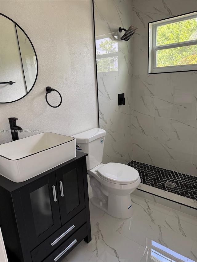 bathroom featuring vanity, toilet, and tiled shower