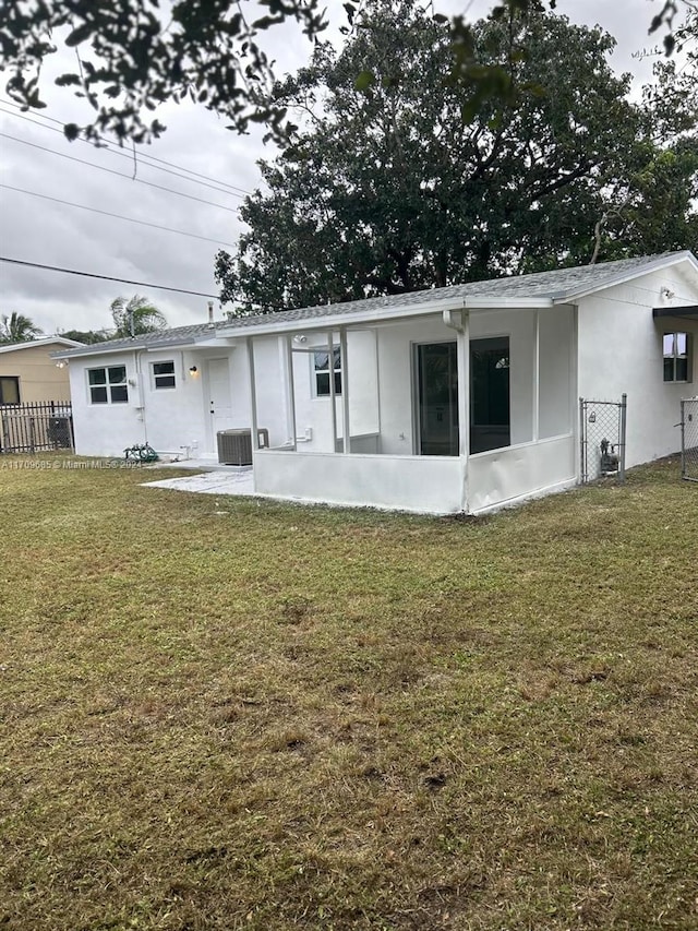 rear view of house featuring a yard and cooling unit