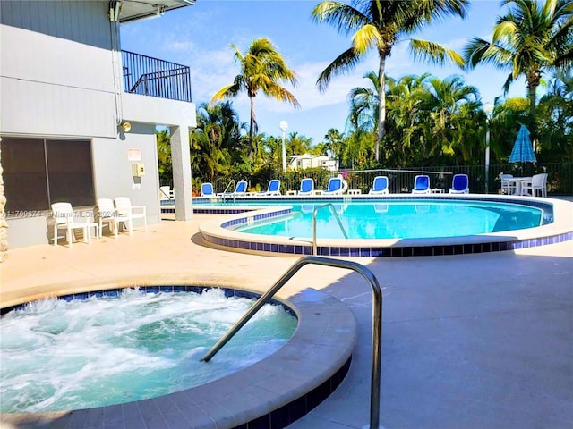 view of pool with a patio and a hot tub