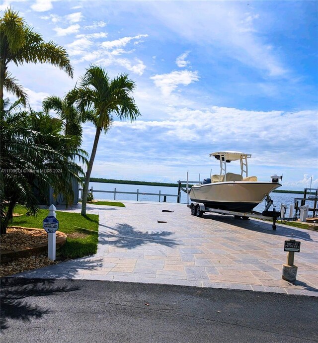 view of property's community featuring a boat dock and a water view