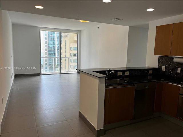 kitchen featuring decorative backsplash, sink, oven, and light tile patterned floors