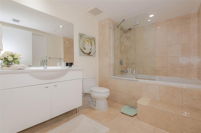 full bathroom featuring toilet, vanity, tiled shower / bath combo, and tile patterned floors