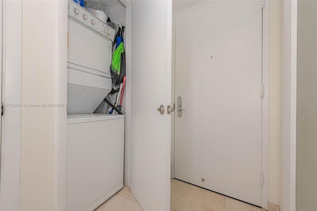 clothes washing area featuring stacked washer and clothes dryer