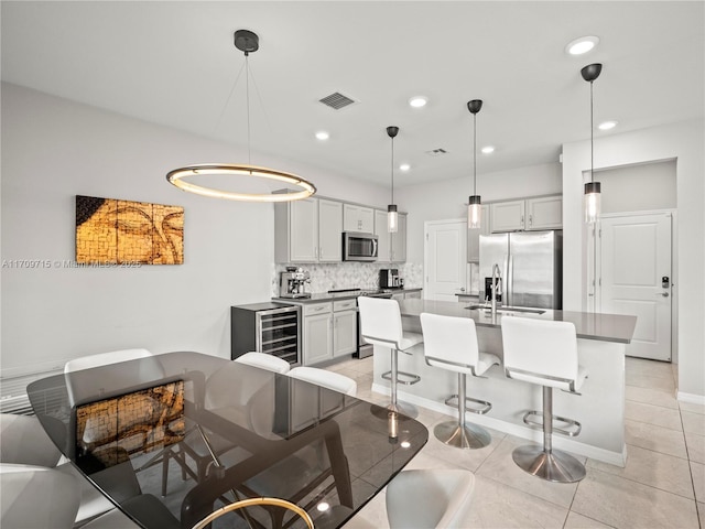 tiled dining area with sink and beverage cooler