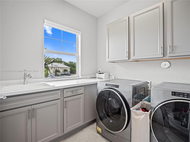 laundry area with sink, light tile patterned flooring, cabinets, and washer and dryer