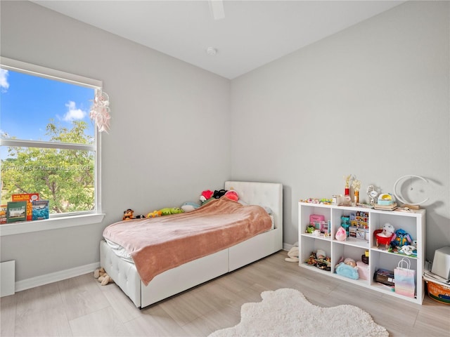 bedroom with light hardwood / wood-style flooring and ceiling fan