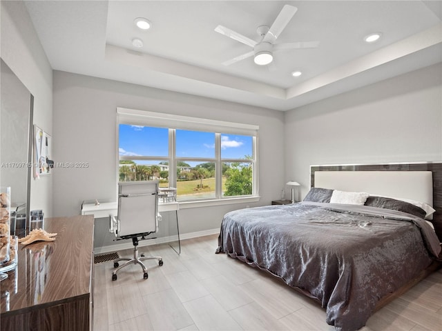 bedroom with ceiling fan and a tray ceiling