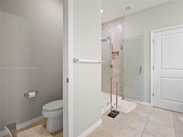 bathroom featuring walk in shower, toilet, and tile patterned floors