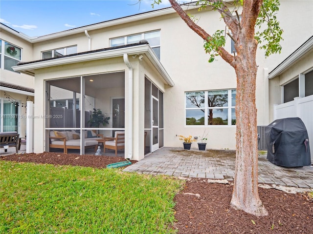 back of house featuring a patio area, a sunroom, and a yard