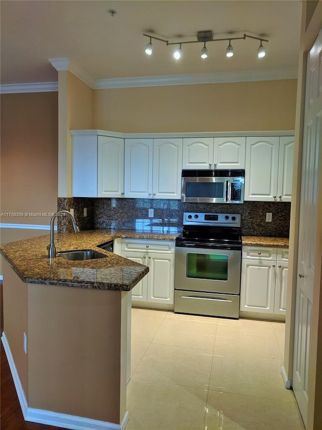 kitchen with backsplash, dark stone counters, sink, kitchen peninsula, and stainless steel appliances