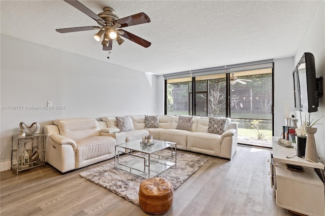 living room with light wood-type flooring and a textured ceiling