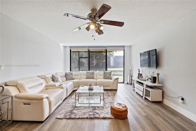 living room featuring floor to ceiling windows, a textured ceiling, light hardwood / wood-style flooring, and ceiling fan