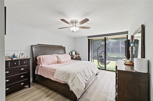 bedroom featuring ceiling fan, access to exterior, a textured ceiling, and light hardwood / wood-style flooring