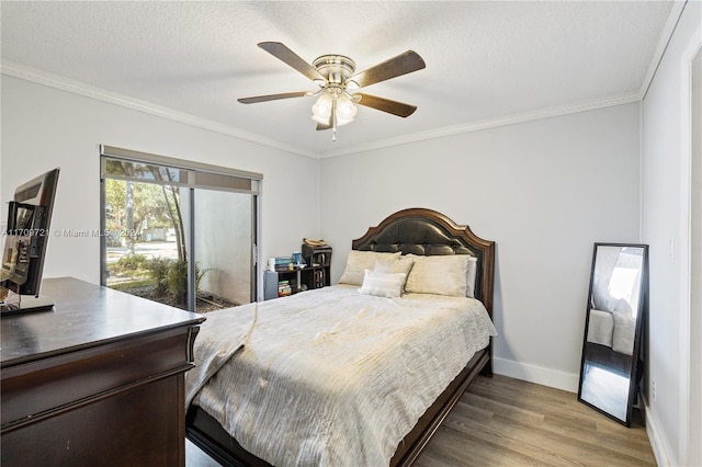 bedroom featuring a textured ceiling, ceiling fan, wood-type flooring, and ornamental molding