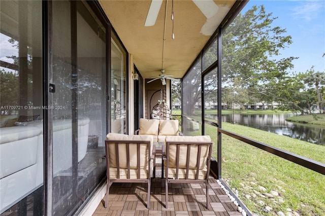 unfurnished sunroom with ceiling fan and a water view