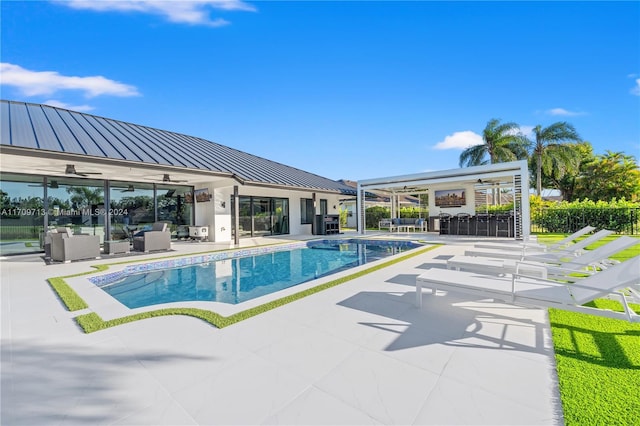 view of pool with ceiling fan, a bar, a patio, and an outdoor hangout area