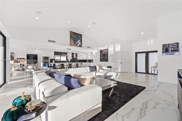 living room featuring french doors and high vaulted ceiling