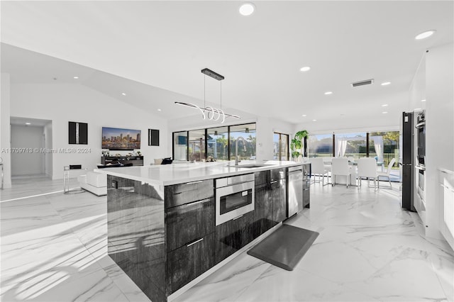 kitchen featuring sink, stainless steel appliances, pendant lighting, a spacious island, and lofted ceiling