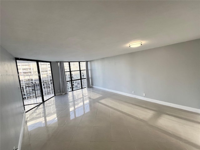 tiled spare room with a wall of windows