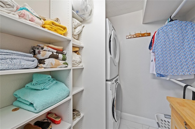 laundry area with stacked washing maching and dryer and a textured ceiling