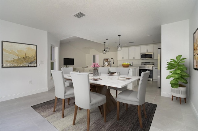 dining area featuring light tile patterned floors, visible vents, and baseboards