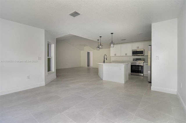 kitchen with visible vents, open floor plan, light countertops, appliances with stainless steel finishes, and white cabinets